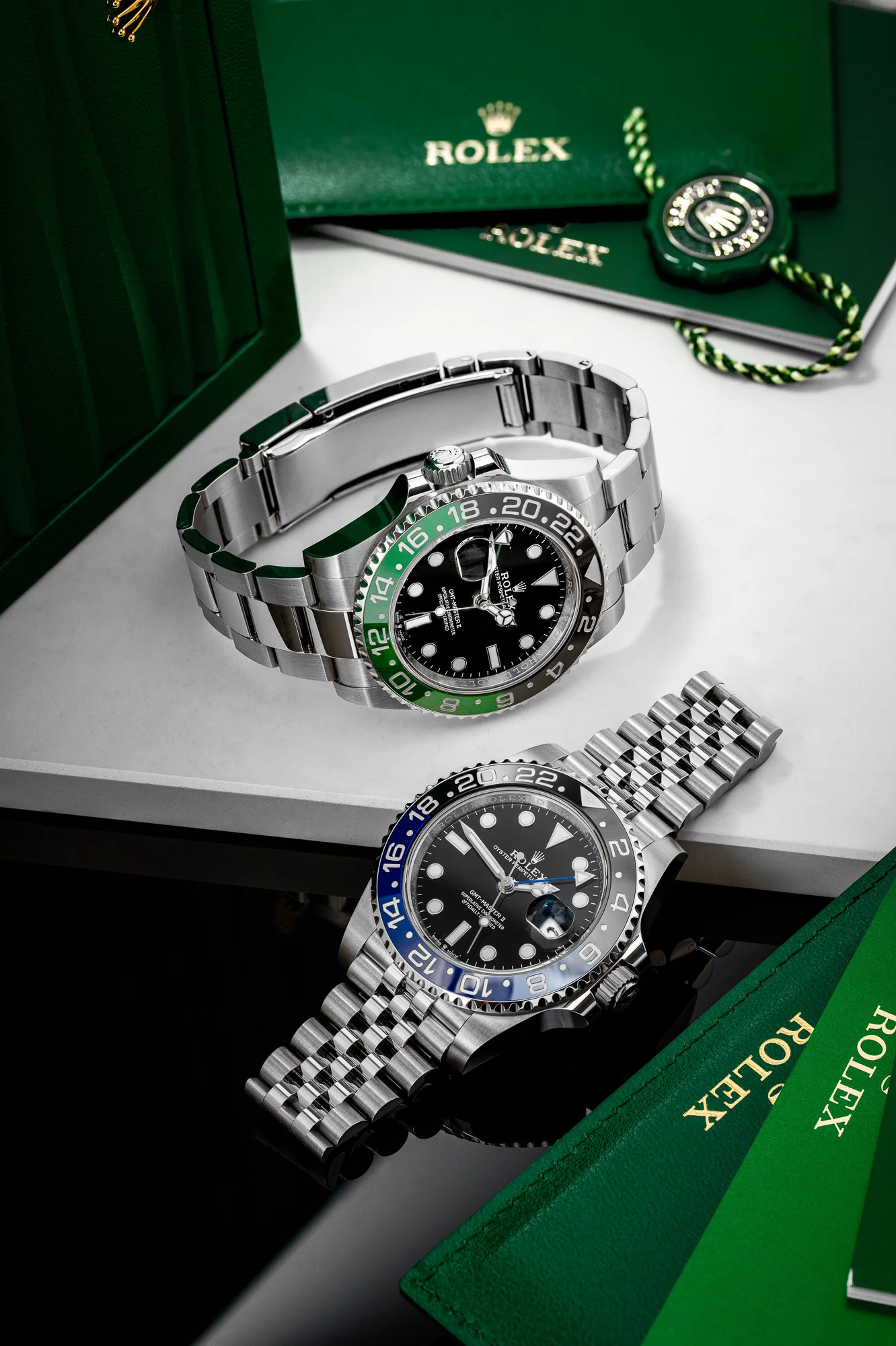 Dwa zegarki Rolex GMT-Master II w kompozycji z zielonymi pudełkami